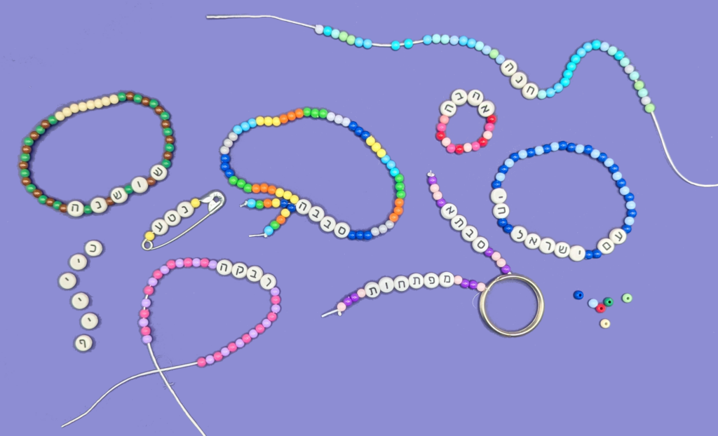 An assortment of bracelets made of white Hebrew beads and pastel plastic filler beads.