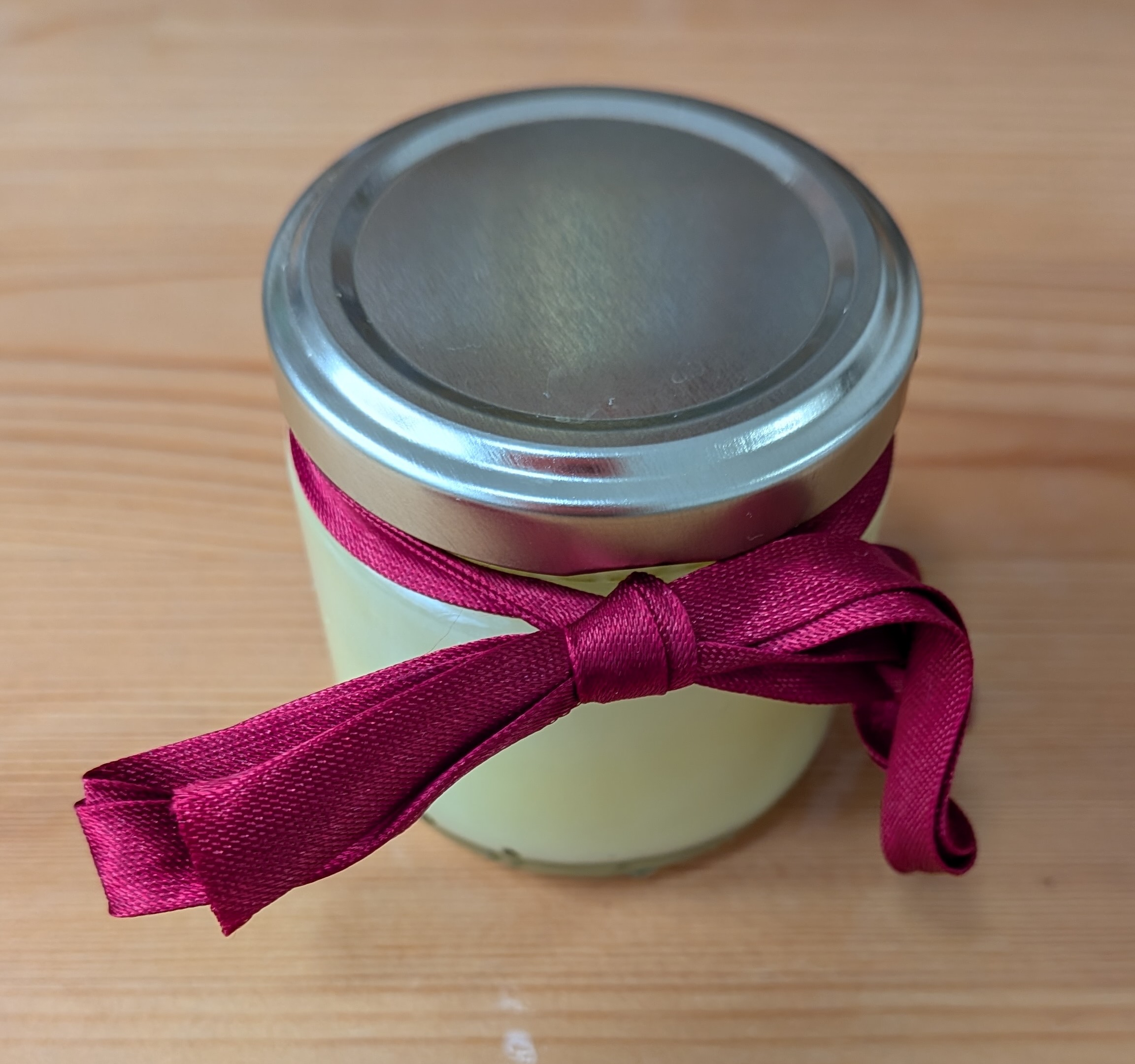 A jar of hand cream, tied with a ribbon.