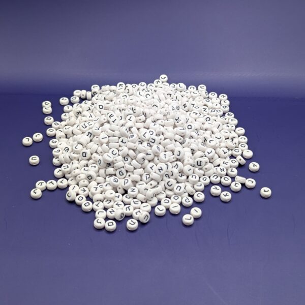 A pile of about 1000 white plastic Hebrew beads on a purple background