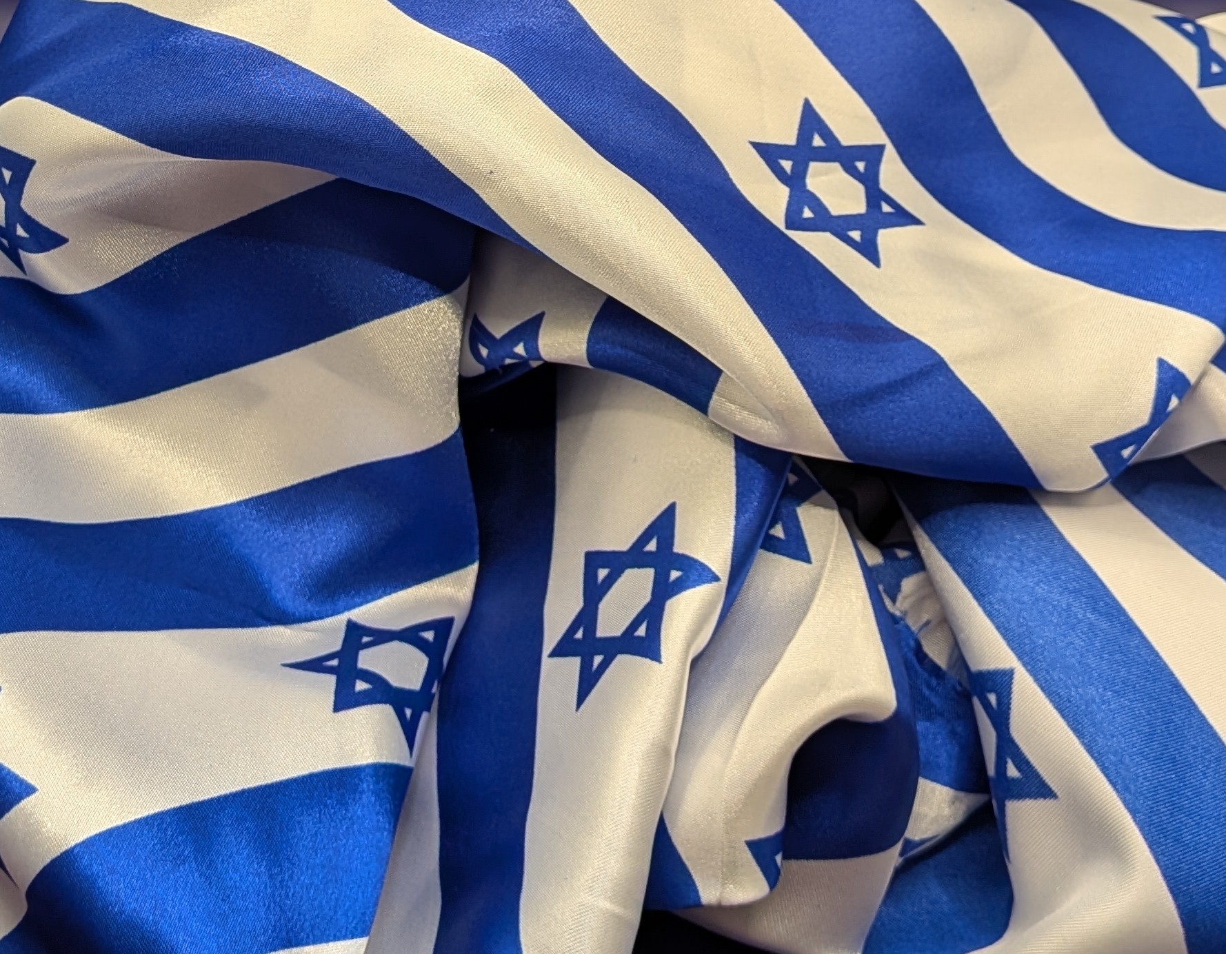 Closeup of a piece of diagonally striped Israeli flag fabric