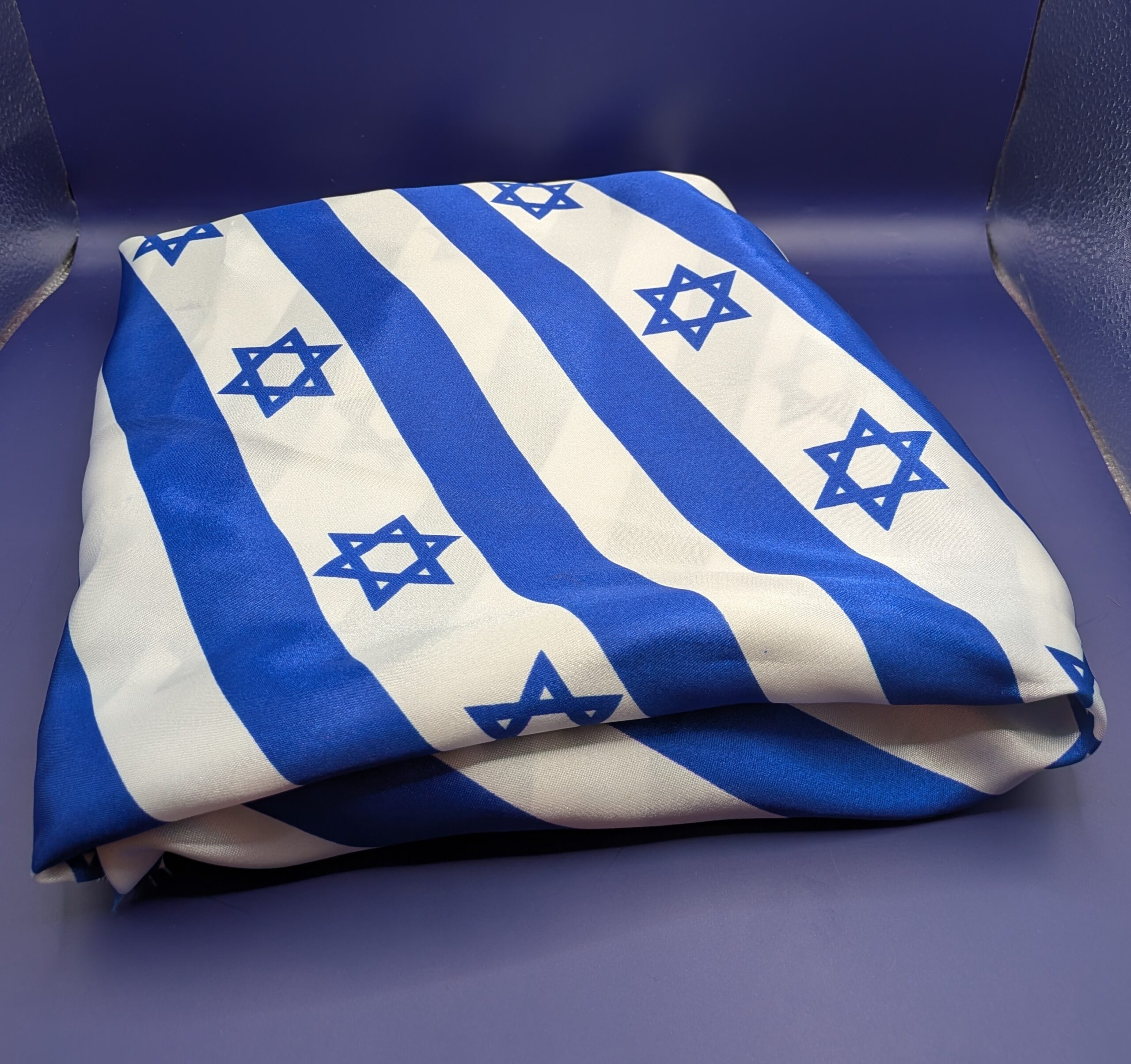 Striped Israeli flag fabric, neatly folded into a rectangle.