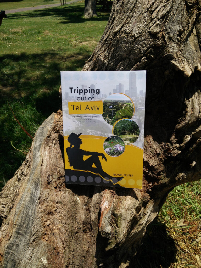 Pic of a hiking book resting on a tree branch.